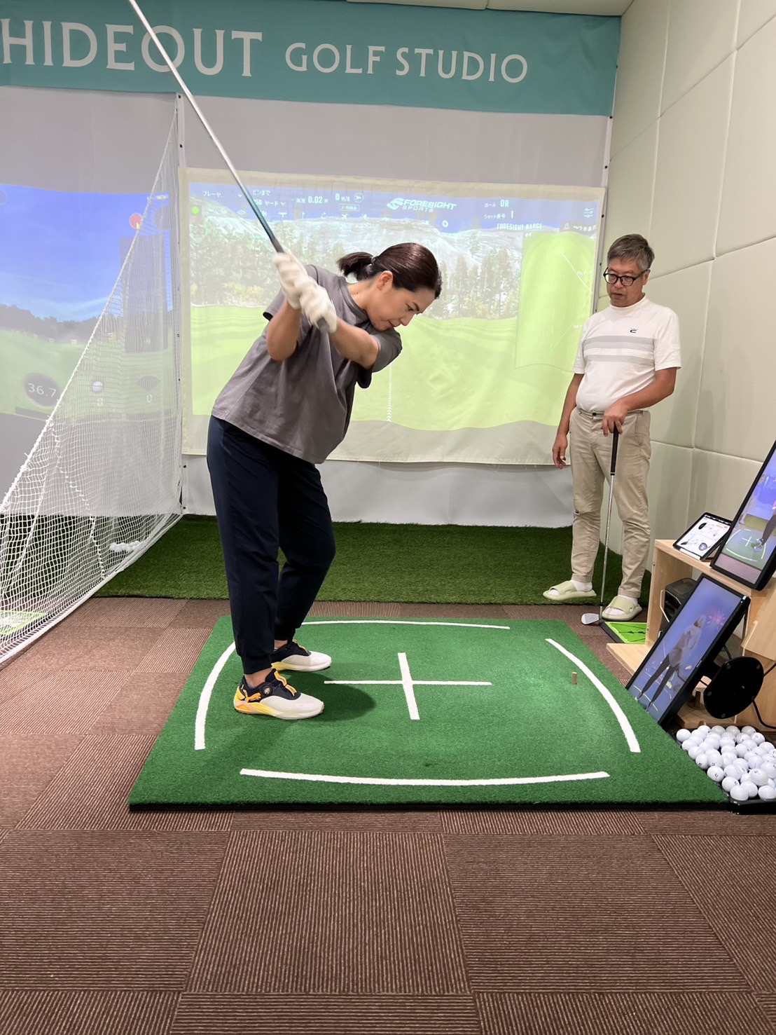 二人でスイングを見せ合いながら練習する様子